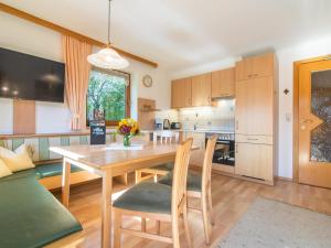 a kitchen and dining room with a wooden table and chairs at Schleicherhof II in Strass im Zillertal