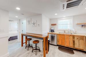 a kitchen with a sink and a counter with stools at Seas the Day in Kitty Hawk