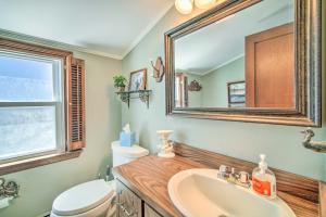 a bathroom with a sink and a toilet and a mirror at Quaint Jersey Shore Apt Walk to Beaches! in Ship Bottom +23 photos