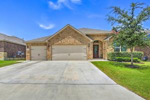 a house with a large driveway in front of it at Suburban San Antonio Home with Covered Patio! in Helotes