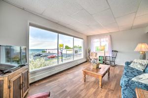 a living room with a couch and a large window at Walkable St Ignace Condo with Lake Huron Views in Saint Ignace