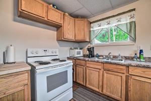 a kitchen with wooden cabinets and a white stove top oven at Walkable St Ignace Condo with Lake Huron Views in Saint Ignace