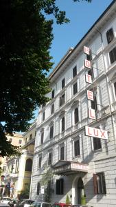 a large white building with a hotel sign on it at Raeli Hotel Lux in Rome