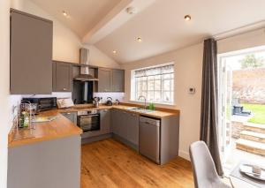 a kitchen with gray cabinets and a large window at The Olde Coach House in Chesterfield