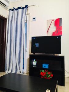 a living room with a table and a television at LuckyGeorge IsimeriaHomz in Thessaloniki