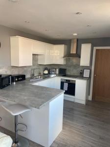 a kitchen with white cabinets and a gray counter top at Spacious one bedroom ground floor apartment in Harrogate
