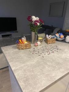 a table with some flowers and baskets on it at Spacious one bedroom ground floor apartment in Harrogate