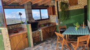 a kitchen with a table and a sink and a stove at Casa Cueva Paquito in Vega de San Mateo