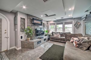 a living room with a couch and a flat screen tv at Pittsburgh Home with Pool, Fire Pit and Game Room in Pittsburgh