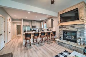 a kitchen with a fireplace and bar stools at Stunning Helen Getaway with Private Hot Tub! in Helen