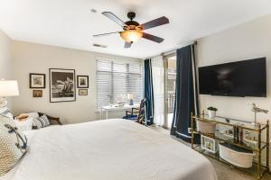 una camera da letto con un letto e un ventilatore a soffitto di Seacliff Retreat Gorgeous third-floor condo with pool, hot tub, & fitness room - walk to beaches a Oceanside