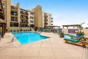una piscina in un hotel con sedie e appartamenti di Seacliff Retreat Gorgeous third-floor condo with pool, hot tub, & fitness room - walk to beaches a Oceanside
