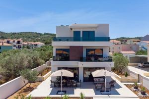an aerial view of a house with tables and umbrellas at NEW! Villa Lady Maris with heated private pool, 5 en-suite bedrooms, 70m from beach in Slatine