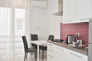 a kitchen with a table and chairs and a sink at Serenis Luxury Apartments in Minori