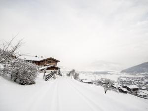 a snow covered hill with a house in the background at Apartment in Kaprun near the ski area in Kaprun