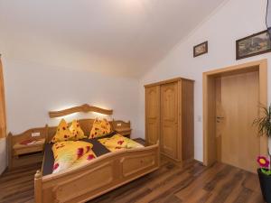 a bedroom with a wooden bed with yellow pillows at Comfortable Apartment in Kaprun near Ski Lift in Kaprun