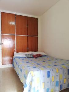 1 dormitorio con 1 cama y armarios de madera en Departamento céntrico Zona La Perla A 100 mts de la playa Muy luminoso en Mar del Plata