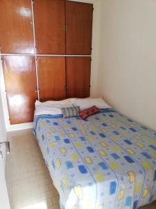 1 dormitorio con 1 cama con edredón azul y amarillo en Departamento céntrico Zona La Perla A 100 mts de la playa Muy luminoso en Mar del Plata