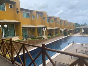 um resort com uma piscina em frente a um edifício em Condomínio Imbassai Summer Flat em Imbassaí