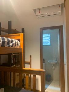 Cette chambre comprend une salle de bains pourvue d'un lavabo et de toilettes. dans l'établissement Condomínio Imbassai Summer Flat, à Imbassaí