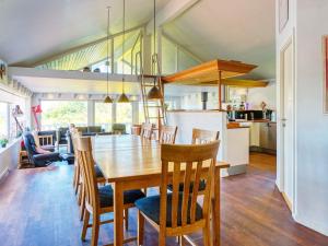 una sala da pranzo e una cucina con tavolo e sedie in legno di Four-Bedroom Holiday home in Sjællands Odde 2 a Yderby