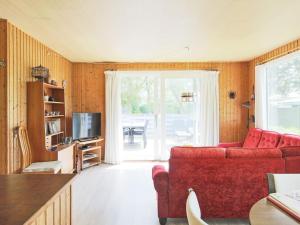 a living room with a red couch and a television at Holiday home Gedser VIII in Gedser