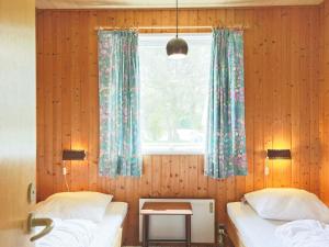 a bedroom with two twin beds and a window at Holiday home Gedser VIII in Gedser