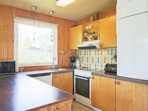 una cocina con armarios de madera y un aparato blanco en Holiday home Gedser VIII, en Gedser