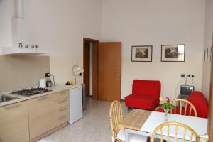 a kitchen with a table and a red chair at Holiday home Fattoria Laghetto in Merate