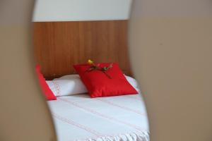 uma cama com duas almofadas vermelhas em cima em Holiday home Fattoria Laghetto em Merate