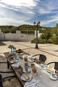 un tavolo in legno con sopra bicchieri da cibo e vino di Jardines de Casablanca a Caravaca de la Cruz