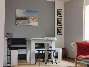 a living room with a white table and stools at Gemütliches Ferienhaus An der Schilde in Renzow