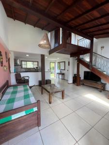 a bedroom with a bed and a living room at Buzios Casa 2 in Búzios