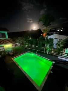una piscina verde en un patio por la noche en Buzios Casa 2, en Búzios