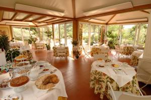 un comedor con mesas blancas con comida. en Marignolle Relais & Charme - Residenza d'Epoca en Florencia