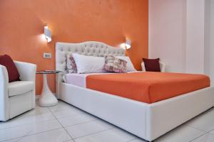 a bedroom with a white bed with an orange wall at Serenis Luxury Apartments in Minori