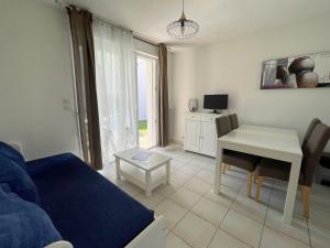 ein Wohnzimmer mit Sofa und Tisch in der Unterkunft Maisonnette 4 pers avec terrasse privée et accès piscine, proche océan - Saint-Brevin-les-Pins - FR-1-364-102 in Saint-Brevin-les-Pins