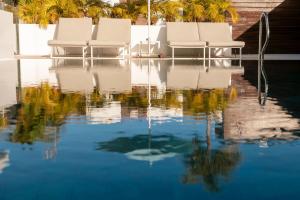 2 chaises blanches assises dans une piscine d'eau dans l'établissement Silvi Villas by TAM Resorts, à Playa del Ingles