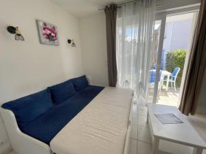 Schlafzimmer mit einem Bett und einem Fenster mit einem Tisch in der Unterkunft Maisonnette 4 pers avec terrasse privée et accès piscine, proche océan - Saint-Brevin-les-Pins - FR-1-364-102 in Saint-Brevin-les-Pins