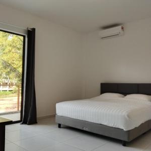 a bedroom with a bed and a window at RIVERSIDE PALM INN SG LEMBING in Sungai Lembing