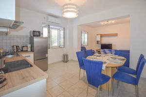 eine Küche und ein Esszimmer mit einem Tisch und blauen Stühlen in der Unterkunft Apartment S and E in Kali
