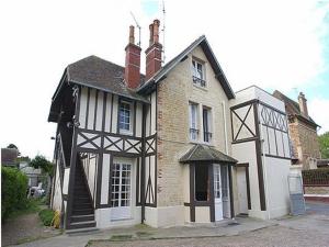 een wit en zwart huis met bij Hotel de Normandie in Saint-Aubin-sur-Mer