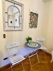 1 mesa y 2 sillas en una habitación con espejo en Bed & Breakfast Lastarria, en Santiago