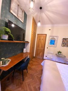 a bedroom with a bed and a desk and a tv at Bed & Breakfast Lastarria in Santiago