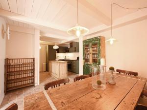 a dining room with a wooden table and a kitchen at Maison Rénovée avec Jacuzzi et Cuisine d'Été au Centre du Village - FR-1-434-97 in La Couarde-sur-Mer +21 photos