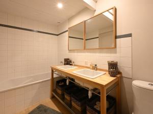 a bathroom with a sink and a mirror and a tub at Maison Rénovée avec Jacuzzi et Cuisine d'Été au Centre du Village - FR-1-434-97 in La Couarde-sur-Mer