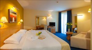 a hotel room with a large bed and a living room at Hotel Saudade in Gradac