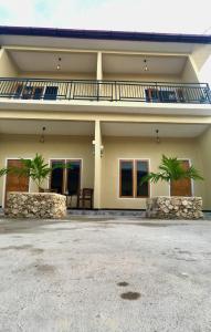 a house with two palm trees in front of it at LOPE HOMESTAY in Ndangu