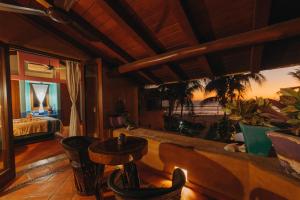 a hotel room with a bed and a table and chairs at Tres Mujeres Hotel in Troncones
