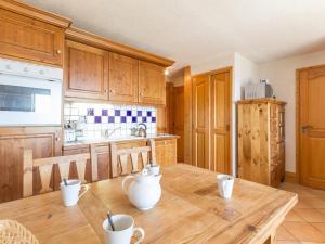 a kitchen with wooden cabinets and a wooden table at Appartement Les Arcs 1800, 3 pièces, 6 personnes - FR-1-346-320 in Arc 1800
